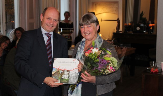 Loco-burgemeester Rob Jorg krijgt het eerste exemplaar van het boek van auteur Annet Werkhoven.