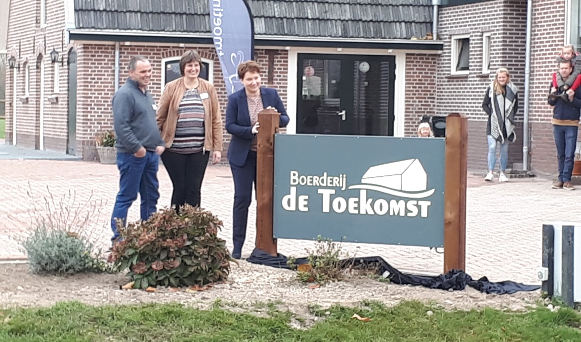 Evert en Martine Legemaat onthullen met wethouder Chantal Broekhuis het bord bij Boerderij de Toekomst.