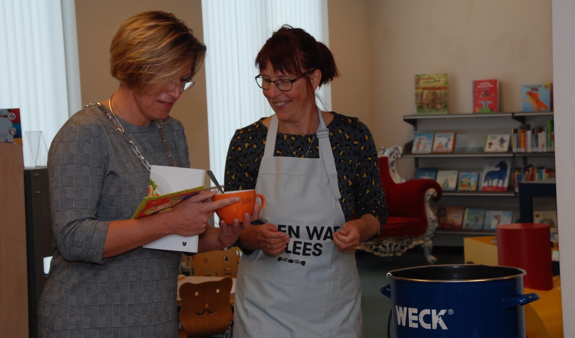 Burgemeester Petra Doornenbal (links) met een boekje en een kop soep.