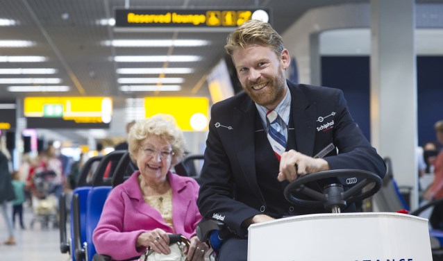 Passagiersassistenten rijden mensen die moeilijk ter been zijn naar de gate.