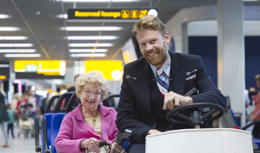 Passagiersassistenten rijden mensen die moeilijk ter been zijn naar de gate.