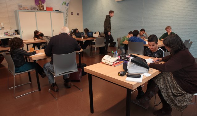 Vrijwilligers van Li Salaam helpen leerlingen met het maken van huiswerk.