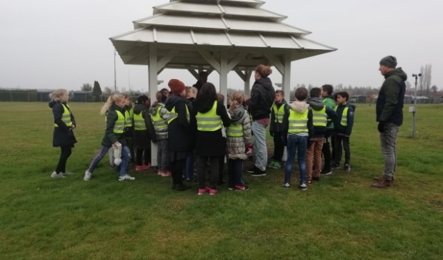 Leerlingen van de Rietakker krijgen uitleg bij de pagode op het waarneemterrein van het KNMI.