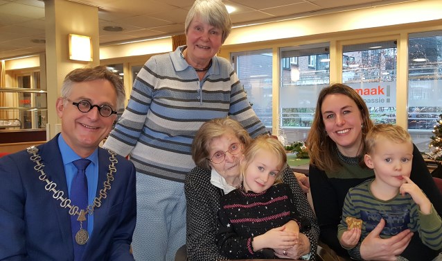 Burgemeester Rob Metz met de 100-jarige mevrouw Cor van Dorrestein en drie generaties kinderen