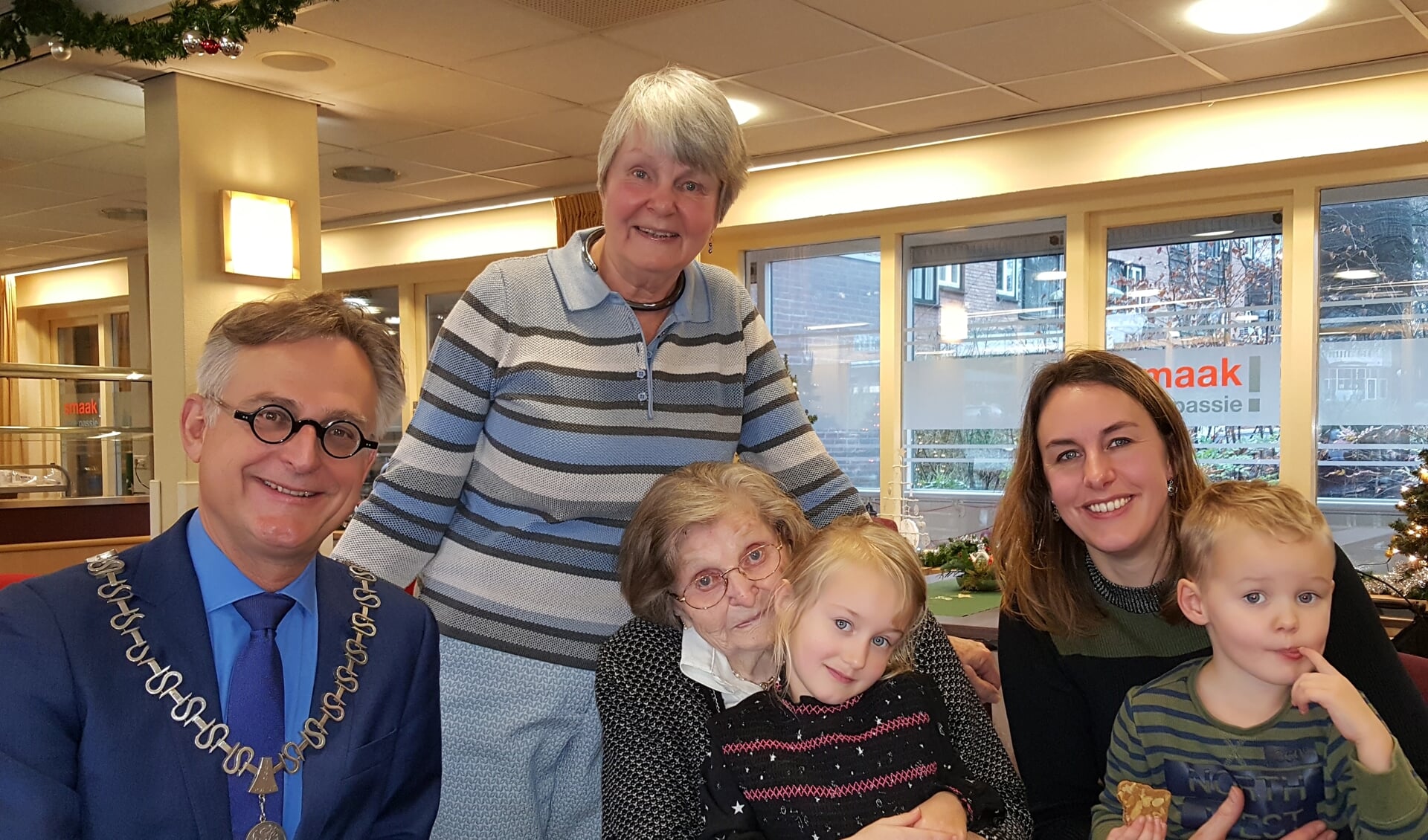 Burgemeester Rob Metz met de 100-jarige mevrouw Cor van Dorrestein en drie generaties kinderen