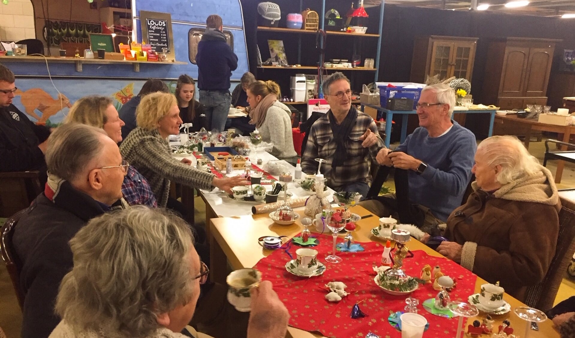 Deelnemers van zorgboerderij Het Middelpunt en Zideris genieten van de sfeer en maken kerststukjes bij Loods Wageningen
