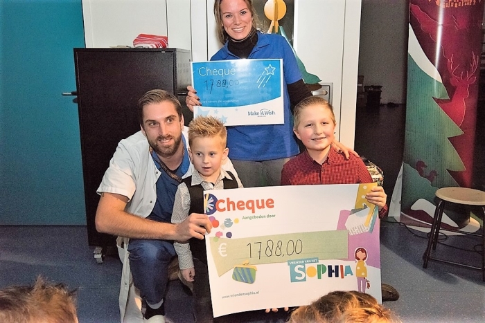 Blije kinderen geven een grote cheque voor zieke kinderen