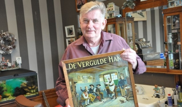 Kapper Hans met de prent die bij zijn vader in de zaak hing. 'Zo wilde ik het ook'. FOTO: Julie Houben