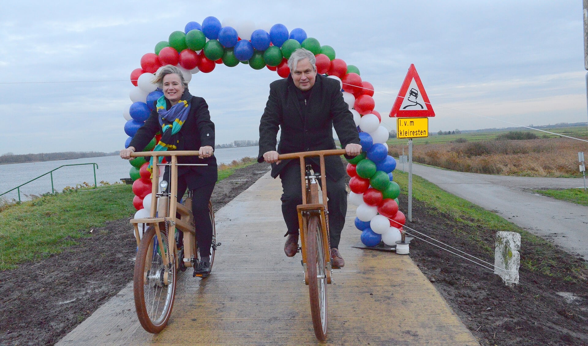 Wethouders Mariëlle Broekman en Wim Oosterwijk openen op de fiets het nieuwe fietspad op de Zeedijk. 
