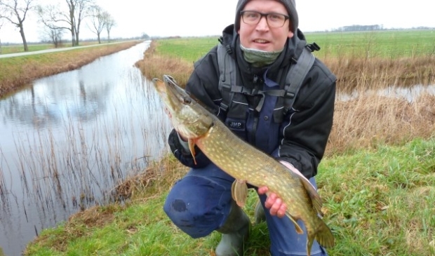 Tim met een snoek. 'Deze gaat zo weer terug het water in'. FOTO: Ernst Jan Bach