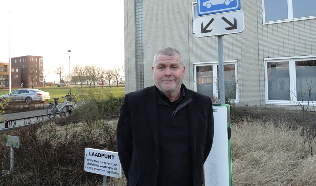 Arie Viskil bij het laadpunt voor elektrische auto‘s bij het gemeentehuis                