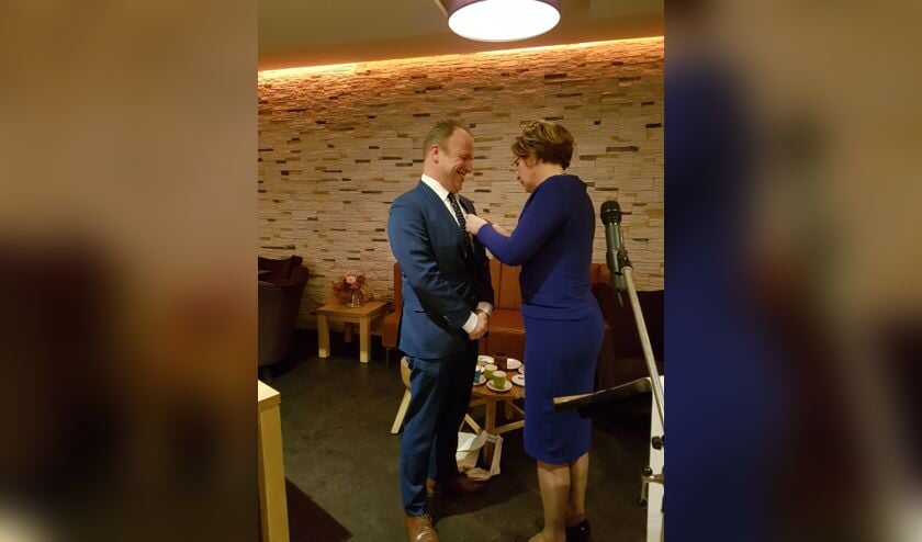 Gert van de Beek krijgt de Koninklijke Onderscheiding opgespeld.