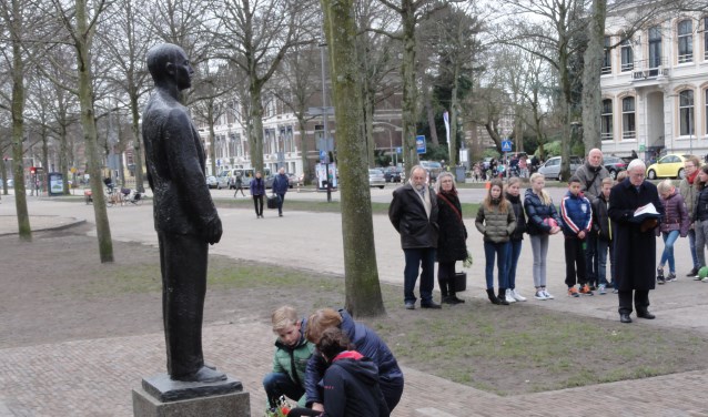 De leerlingen van de Dreefschool leggen een roos bij het monument.