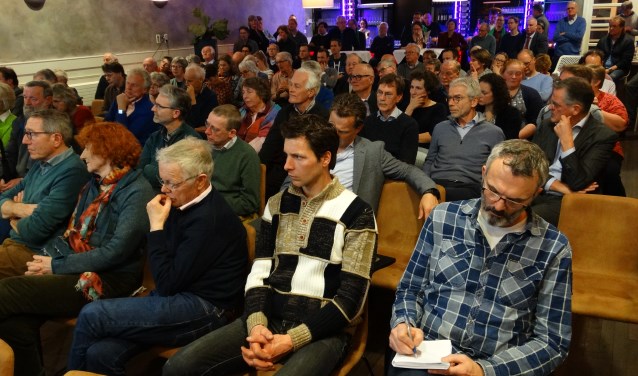 Volle zaal met toehoorders, mensen met zinvolle vragen aan de politiek