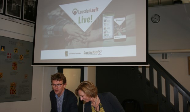 Jan Overweg (wethouder) en Hester Frank (directeur Larikslaan2) demonstreren app ‘LeusdenLeeft’.