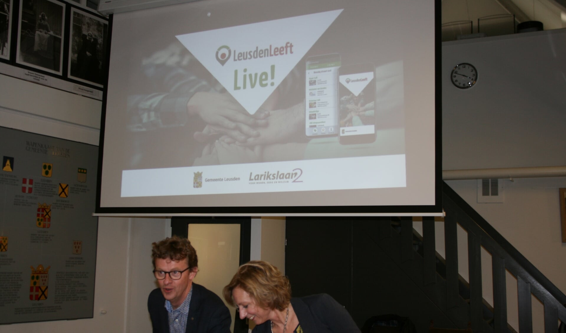 Jan Overweg (wethouder) en Hester Frank (directeur Larikslaan2) demonstreren app ‘LeusdenLeeft’.