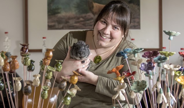 Mireille Klinkenberg tussen haar hobby's. Op de achtergrond een prent van Schotland.