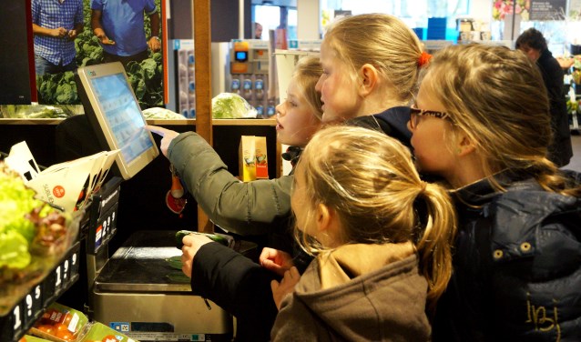 Leerlingen Eline, Anna, Sophie en Cleo wegen nauwkeurig hun gekochte komkommer.