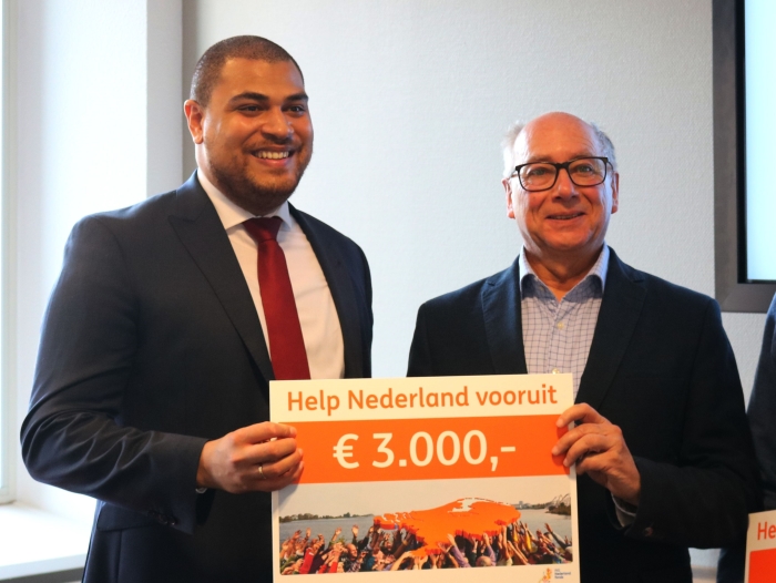 Voorzitter D. Koppelaar ontvangt de cheque uit handen van dhr Ramzam van de ING