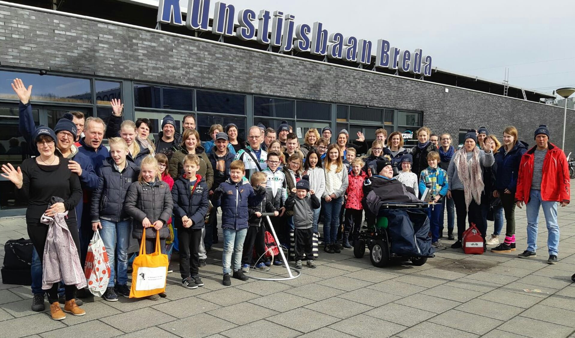 De groep dolenthousiaste schaatsliefhebbers bij de ingang van de kunstijsbaan in Breda.