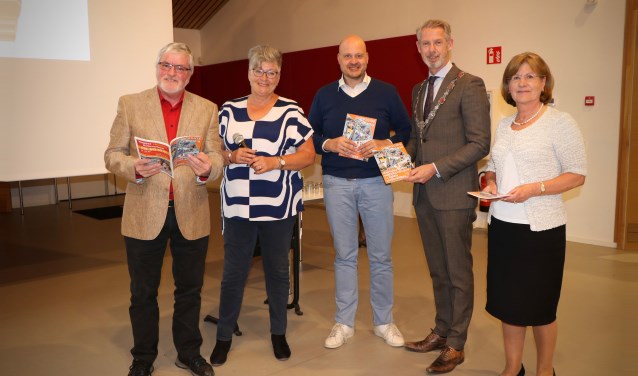 Burgemeester Hoes en de prijswinnaars van de fotowedstrijd ontvangen de eerste Dorpsgids editie 2018-2019