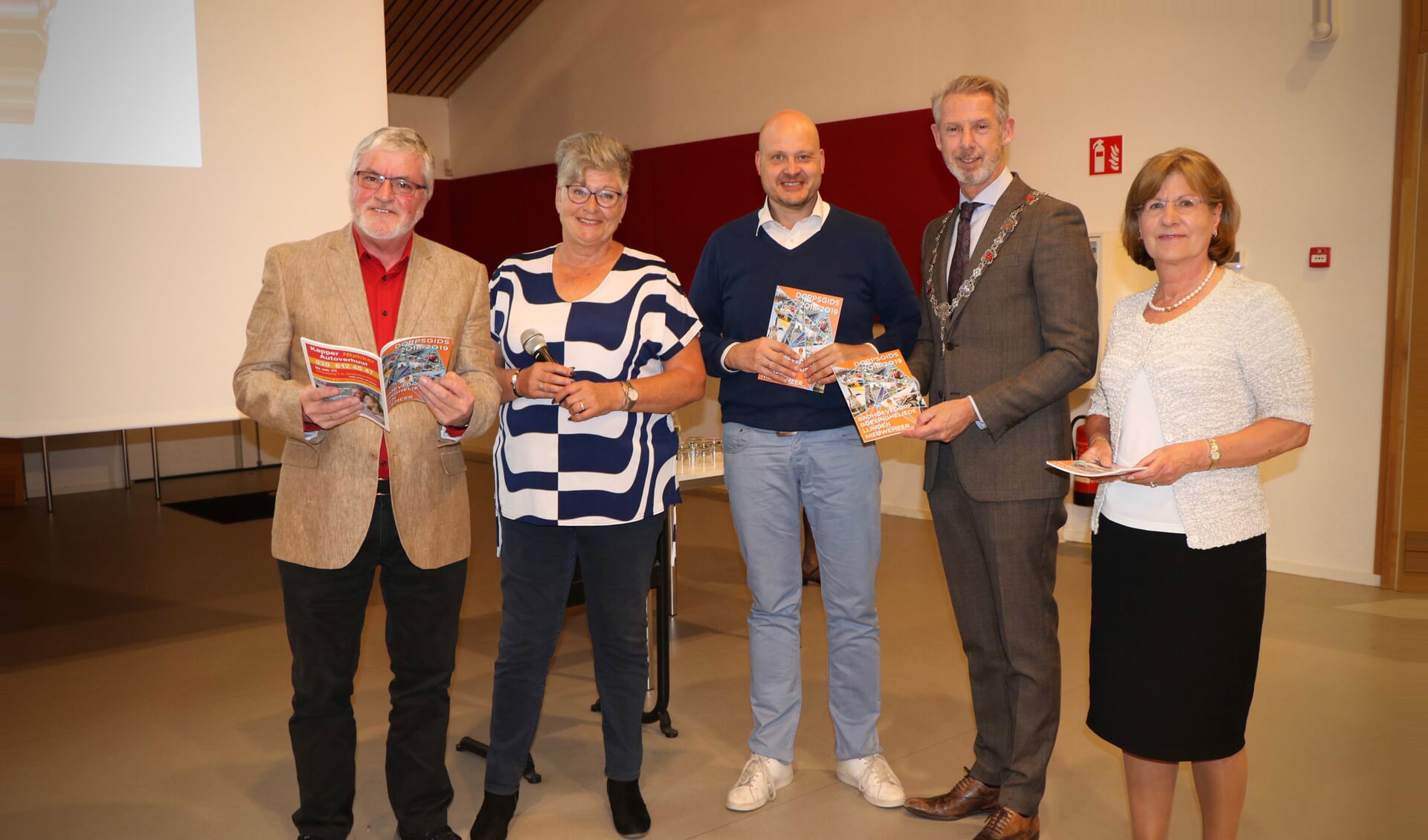 Burgemeester Hoes en de prijswinnaars van de fotowedstrijd ontvangen de eerste Dorpsgids editie 2018-2019