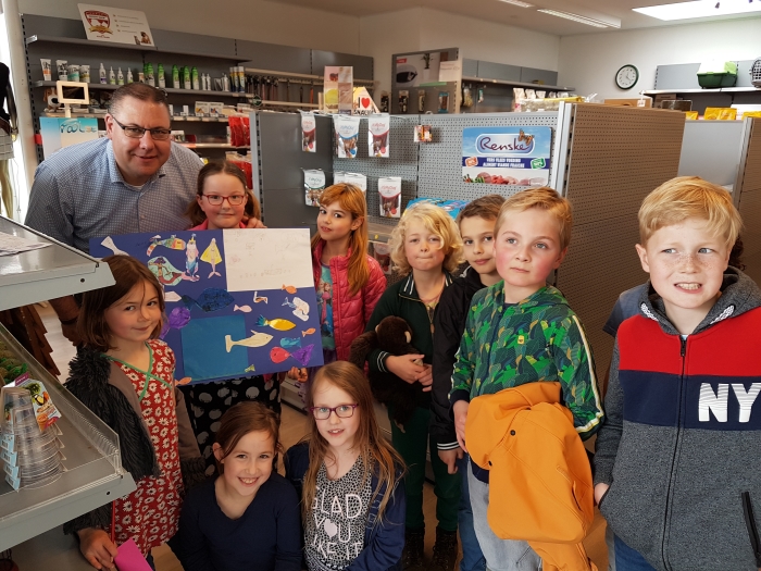 Een blije meneer Peter met een aantal leerlingen