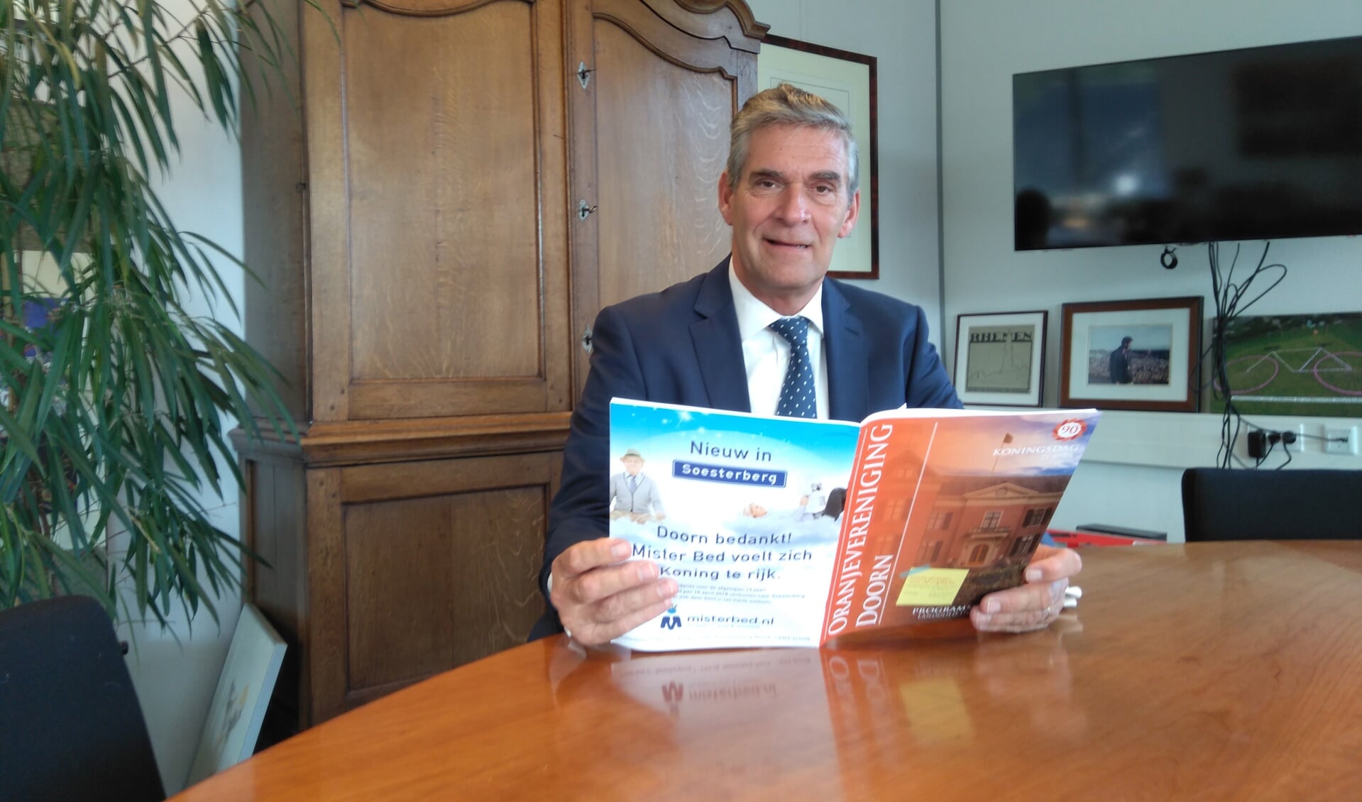 Frits Naafs met het magazine van de Oranjevereniging Doorn. 