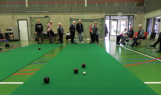 Bij koersbal wordt er twee tegen twee gespeeld op een lange groene mat.