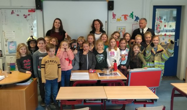 Na een uur lang luisteren en vragen afvuren, wilden de kinderen allemaal met de brandweerman en zijn uitrusting op de foto.