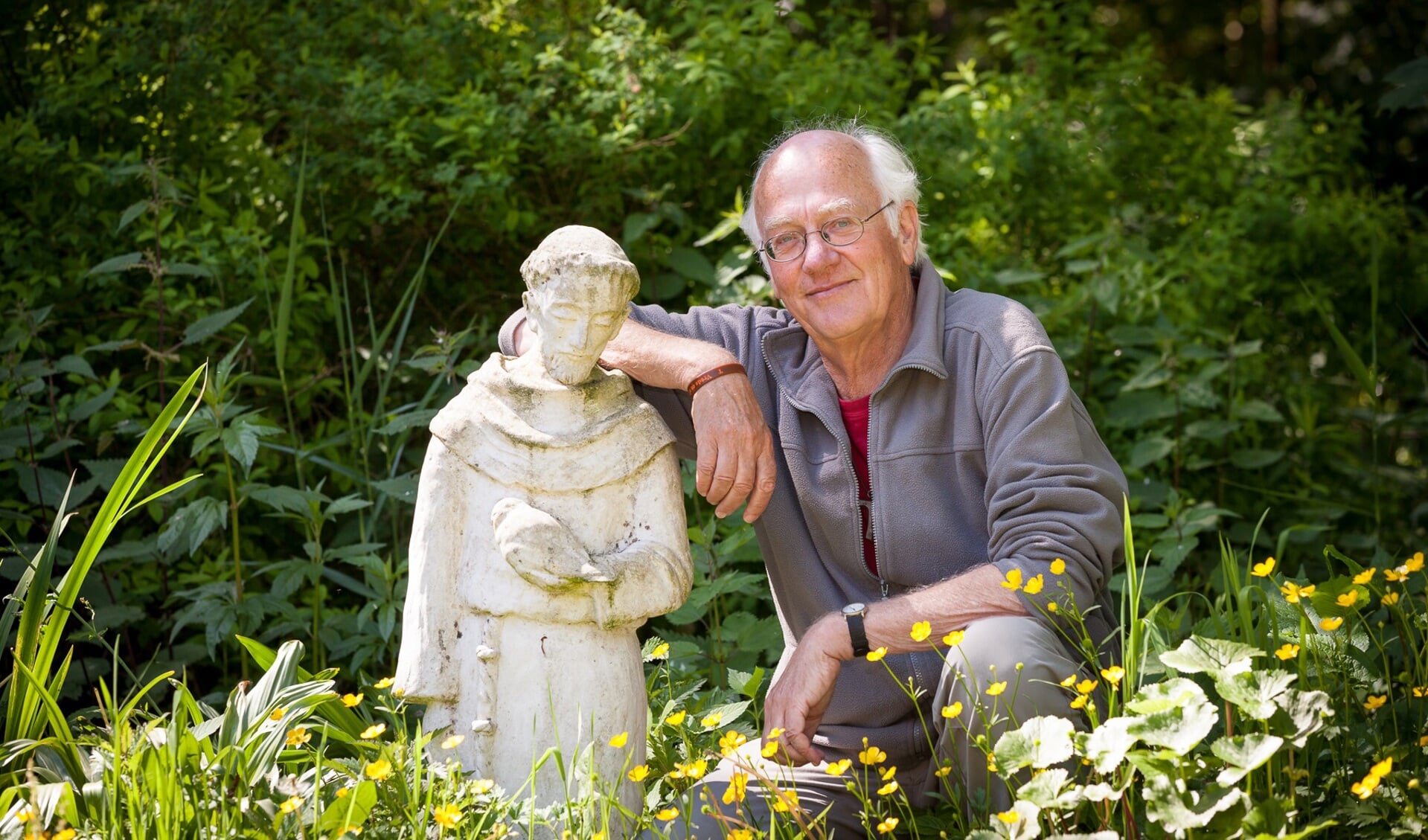 Guy Dilweg naast een beeld van Franciscus van Assisi