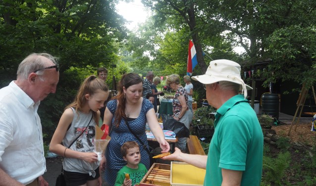 Imkers geven enthousiast uitleg over bijenwas en honing. De opening van de speciale tuin trok veel belangstelling.