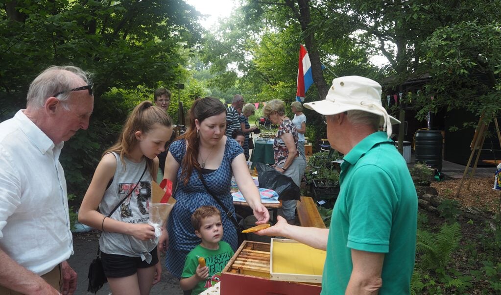 Imkers geven enthousiast uitleg over bijenwas en honing. De opening van de speciale tuin trok veel belangstelling.