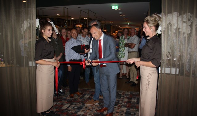 Wethouder Kiel knipt onder toeziend oog van eigenaar Hu het lint door.
