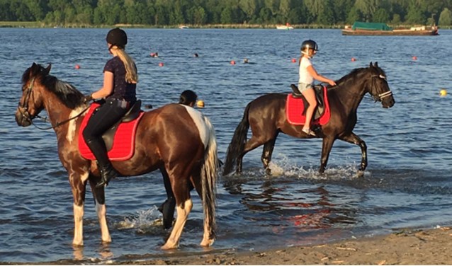 De meisjes genieten op de paardenruggen.