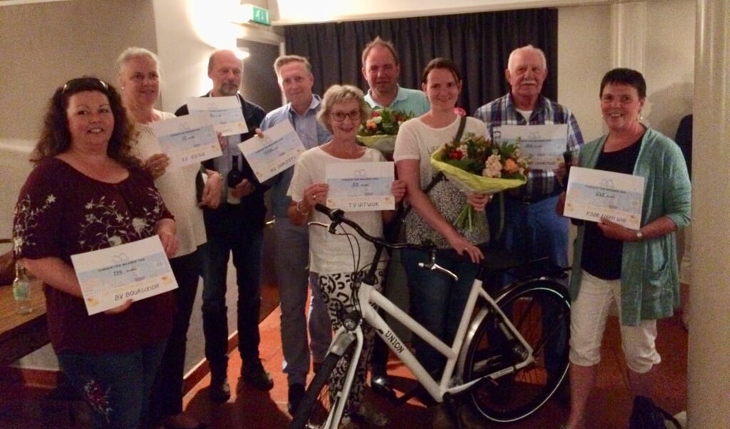 Op de foto de hoofdprijswinnares met de gewonnen fiets, de sponsor van de hoofdprijs en vertegenwoordigers van de deelnemende verenigingen.