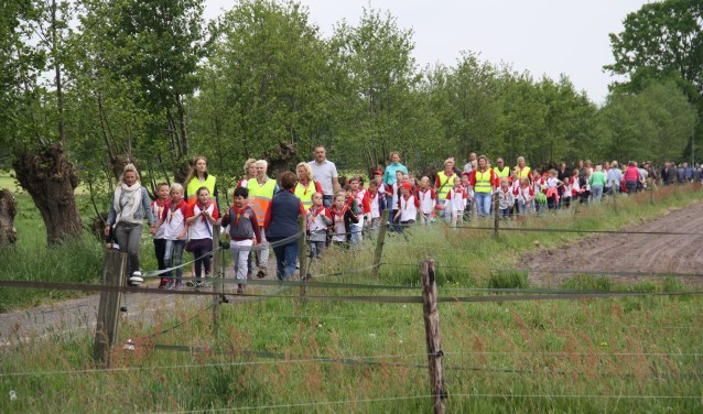 De deelname van schoolkinderen geeft een vrolijke stoet.