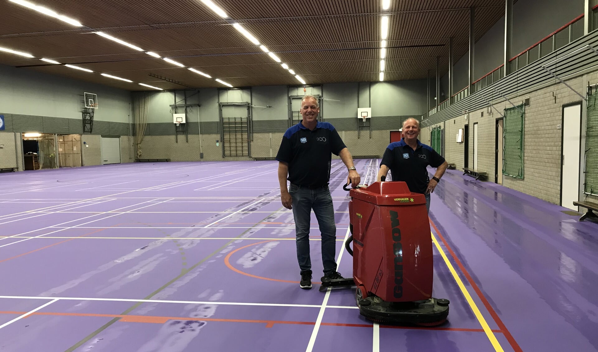 Sporthuis medewerkers Peter Goes (links) en Marcel Miltenburg zijn enthousiast over de nieuwe vloer, die hier de eerste schoonmaakbehandeling heeft gehad.