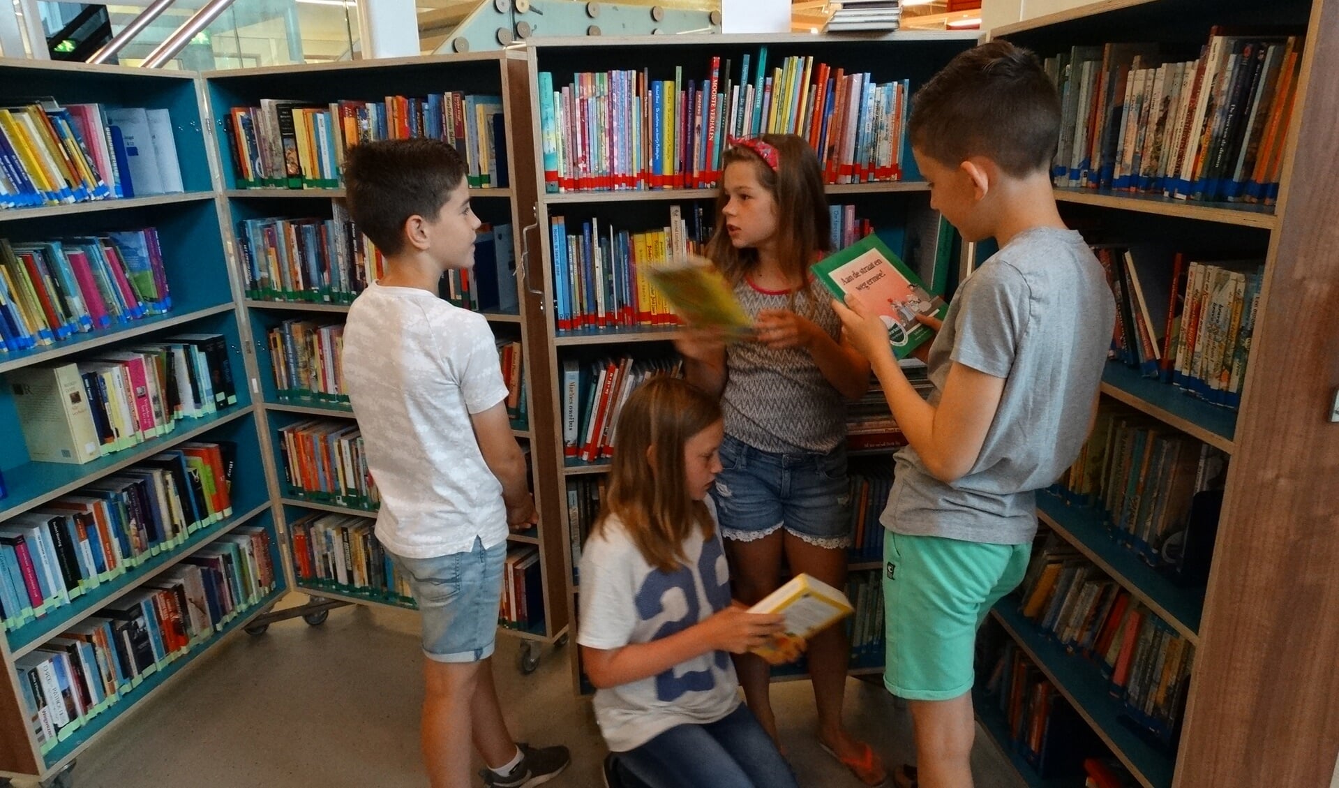 Lars, Job, Willemijn en Amélie van groep 7 van de Delteykschool zoeken boeken uit