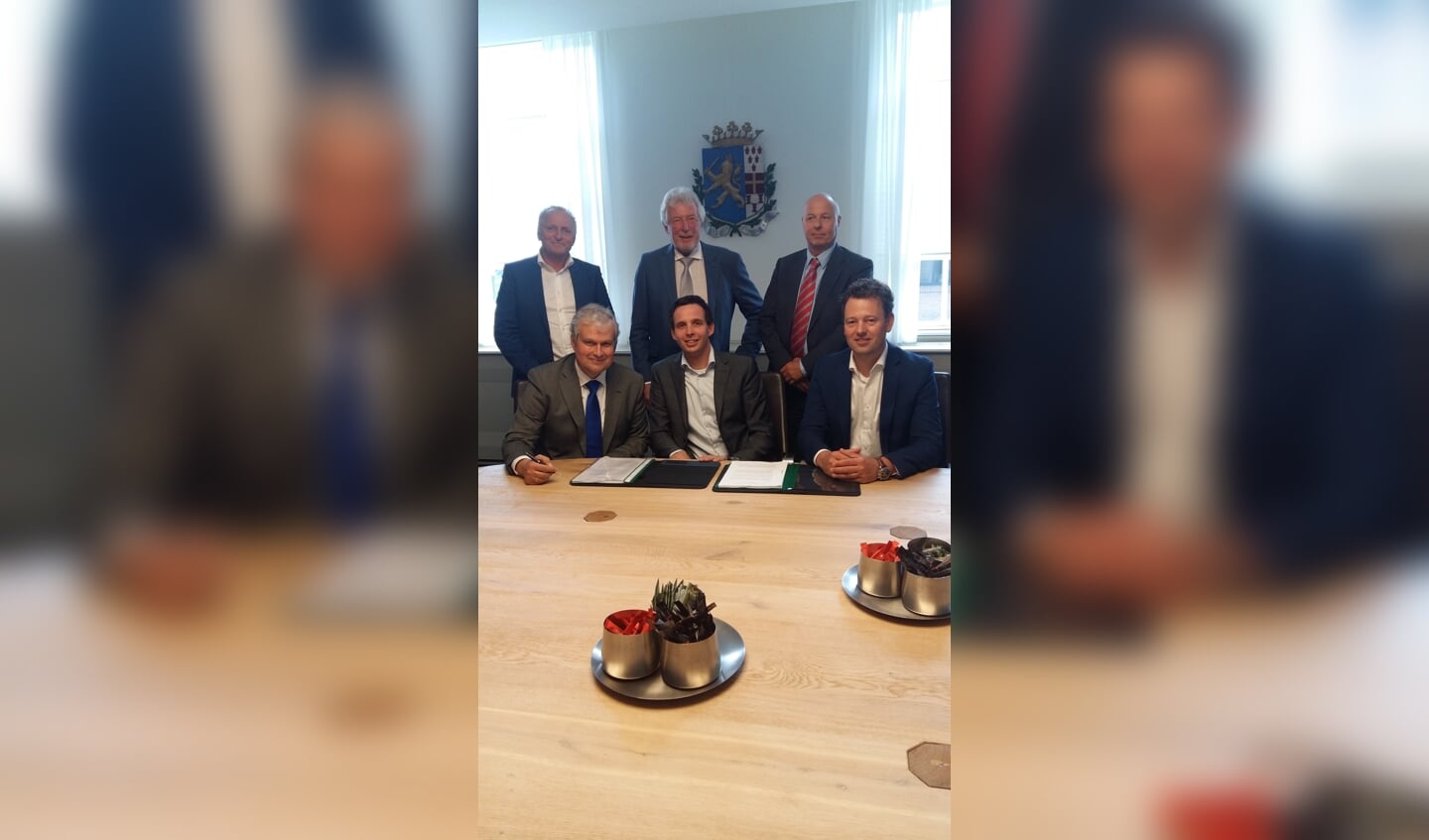 Wethouder Wim Oosterwijk, Wouter van den Top, Henk van de Kolk (voorste rij zittend) en Wilgo van de Mheen, Cor Vos, en Douwe Jan Tilkema (staand) plaatsen hun handtekening onder de exploitatieovereenkomst.