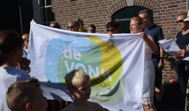 Door een vlag omhoog te houden, wordt al zingend de nieuwe naam onthuld
