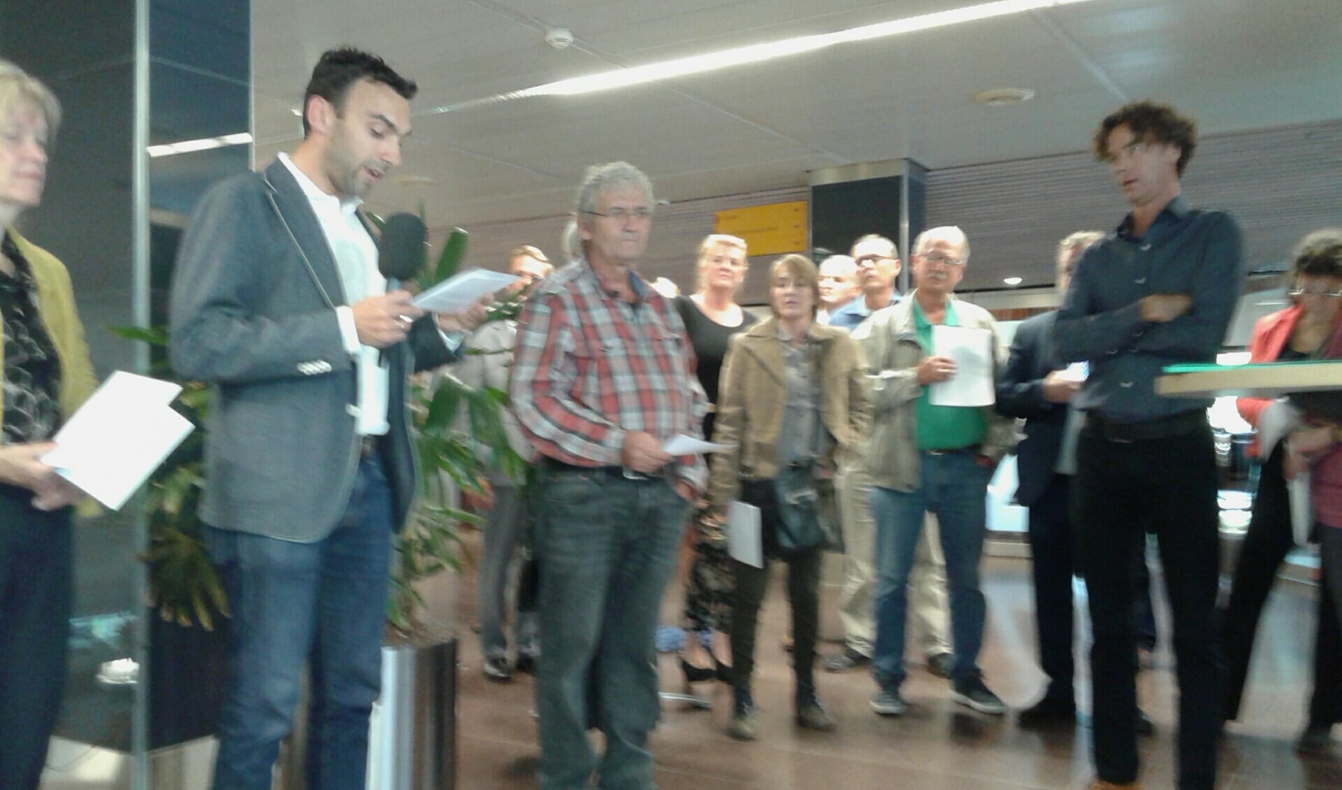 Christian van Barneveld (links, Groen in Amersfoort) overhandigt een petitie aan raadsvoorzitter Ben van Koningsveld (rechts). 