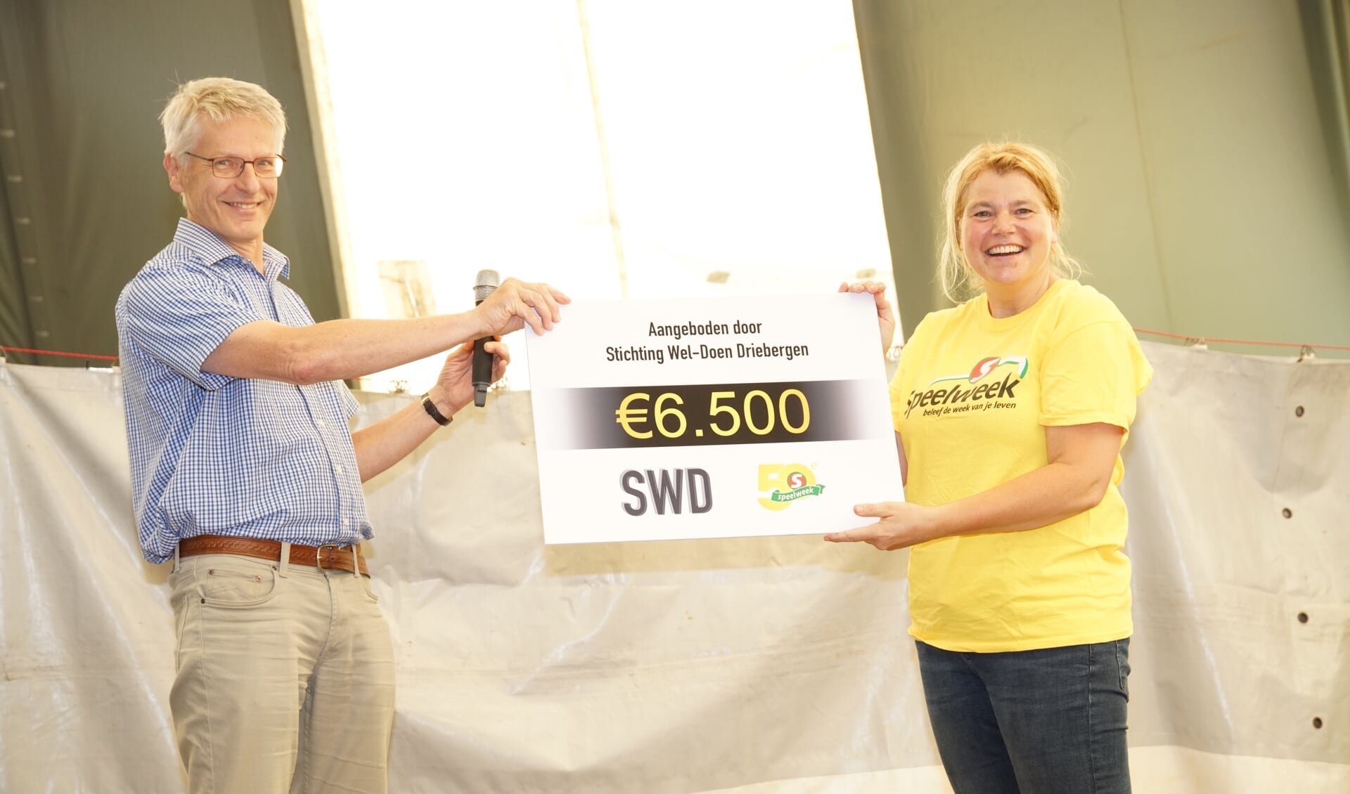 Voorzitter van Stichting Wel-Doen Driebergen Clemens Festen overhandigt de cheque aan Caroline van Veen, voorzitter van Stichting Jeugd Rekreatie Driebergen.