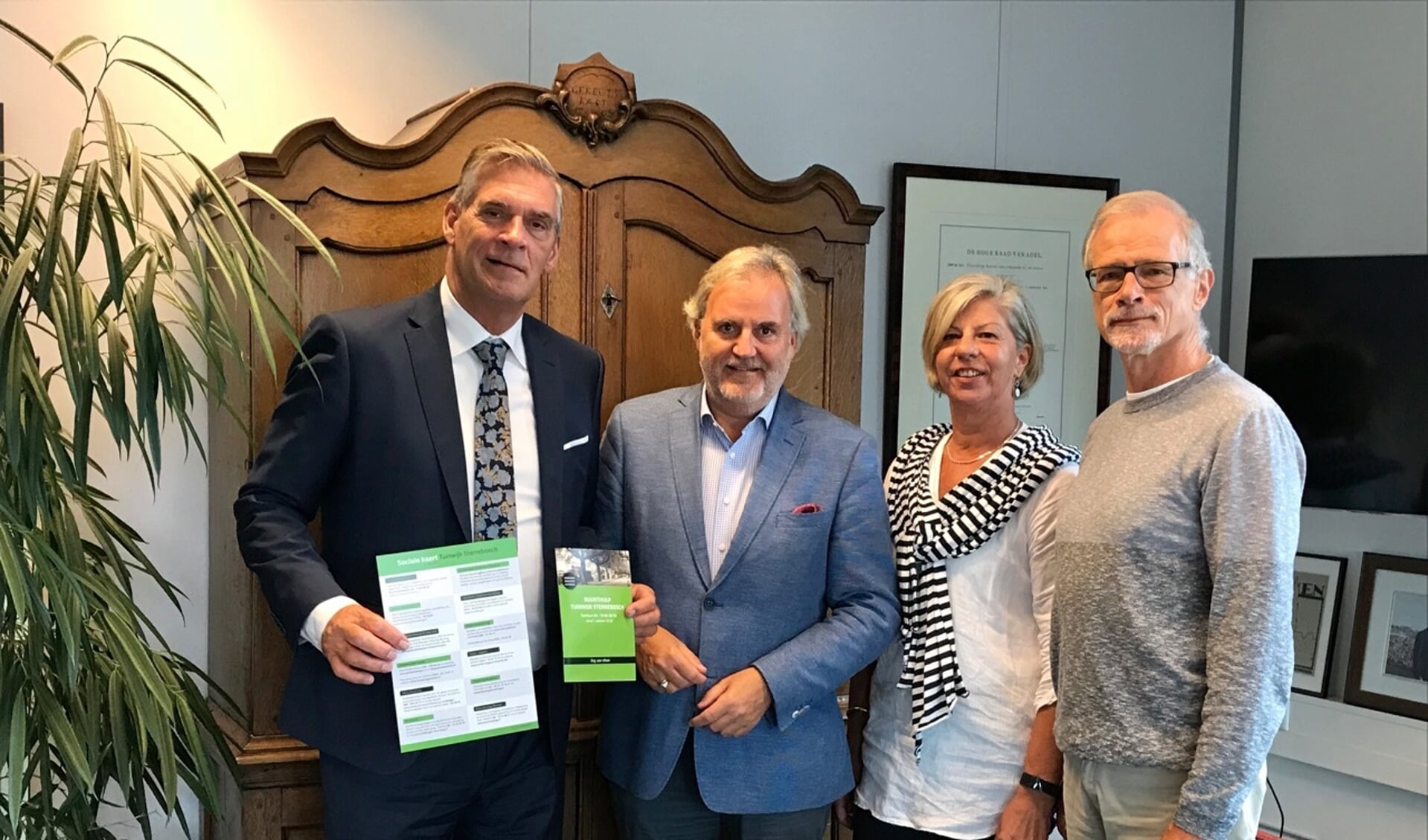 Burgemeester Naafs krijgt uit handen van Bram Brinkman, Delia Vermeulen en Hans Nieuwenhuijs de eerste sociale kaart.