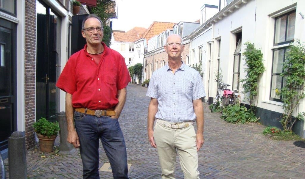 Rik ten Cate (l) en Anton van Kolfschoten voor enkele van de deelnemende woningen in de Muurhuizen. 