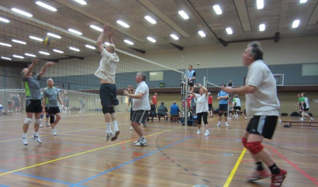 Recreatieve volleyballers in actie.