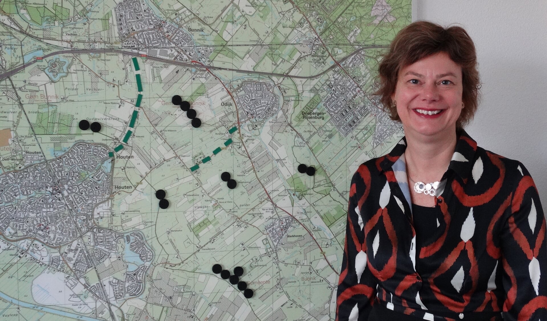 Wethouder Erika Spil (P21) bij de kaart met locaties: de zwarte cirkels staan voor het maximum aantal windmolens 