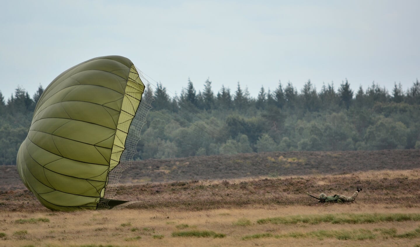 De parachute wordt door de harde wind over de heide getrokken