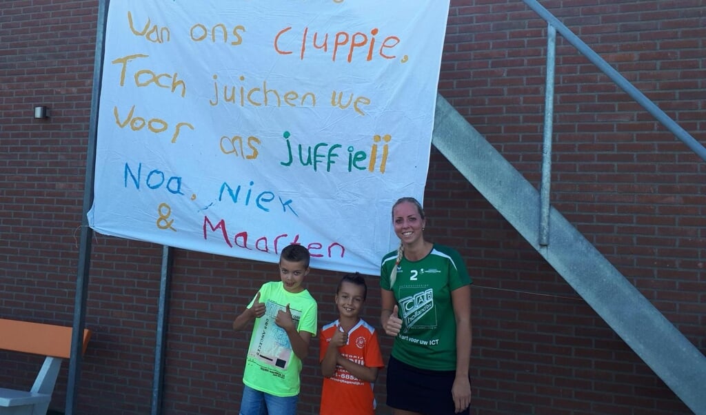 Vriendnschaarsteren onderwijzeres Milou van Dijk met Oranje Wit kinderen voor het spandoekmet haar leerlingen van de Julianaschool 