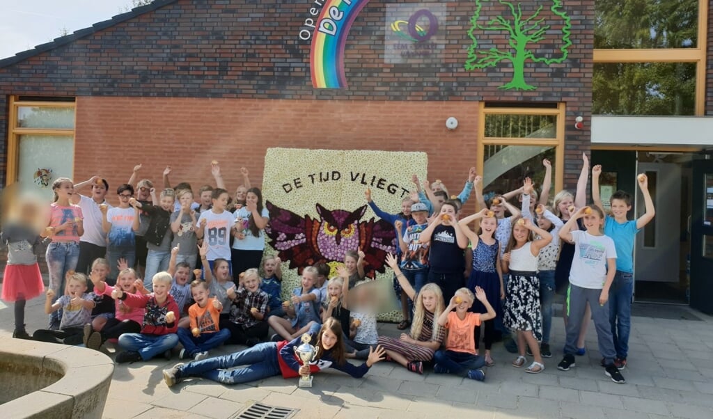 Trotse leerlingen van groep 5-8 voor het winnende paneel mét de wisselbeker en de traktatie. 